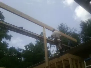 Carpenter setting a ridge beam over a new addition frame — Ice Dam Removal by Roofing Brothers in Galivants Ferry