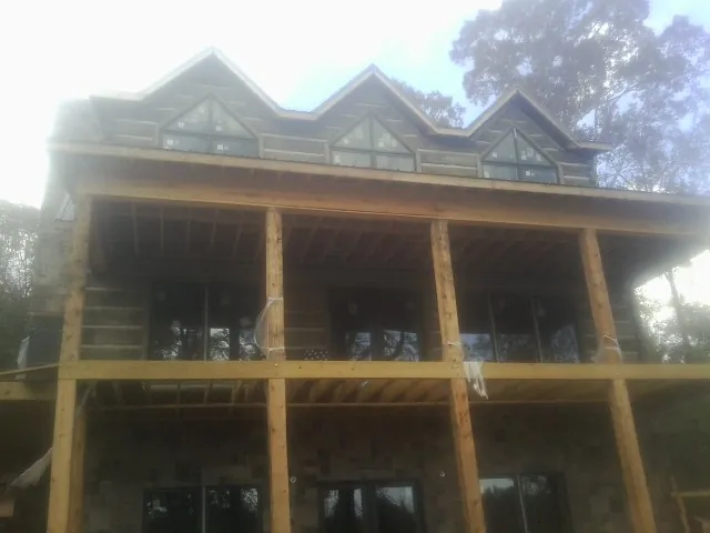 Dormers and porch framing on a large log home under construction — Roof Coating work by our crew in Galivants Ferry