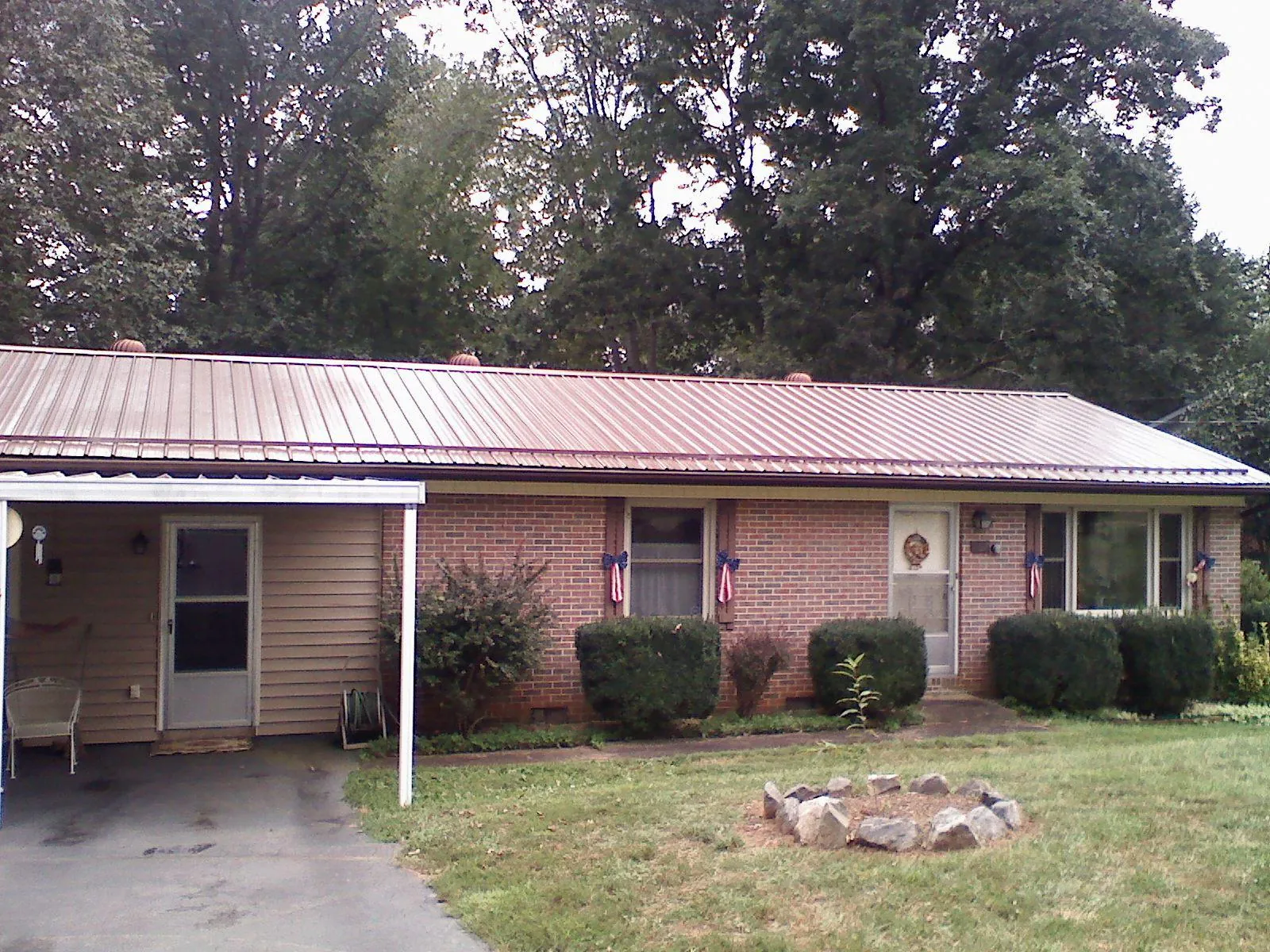 Bronze metal roof and carport on a brick ranch home — Roof Repair work by our crew in Galivants Ferry